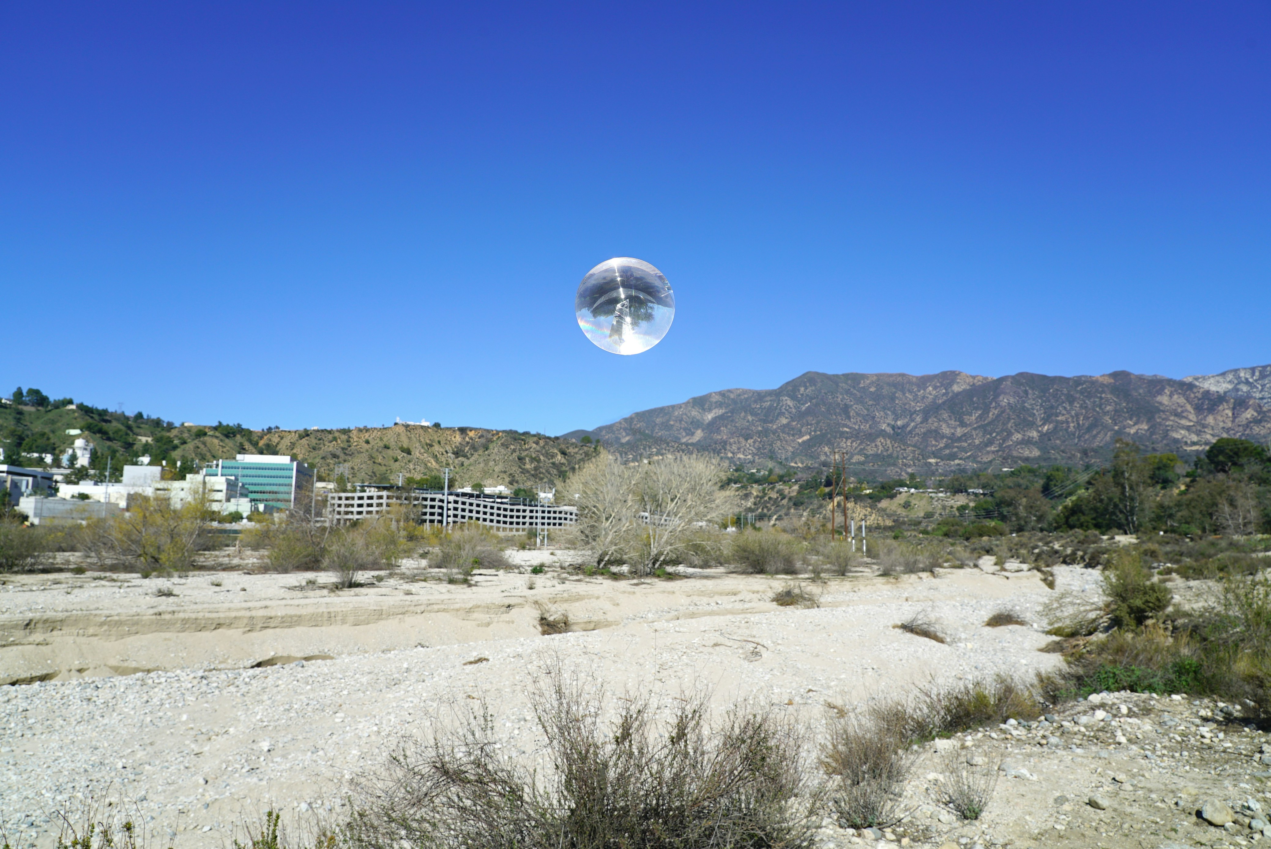 Crystal ball floating above desert landscape.