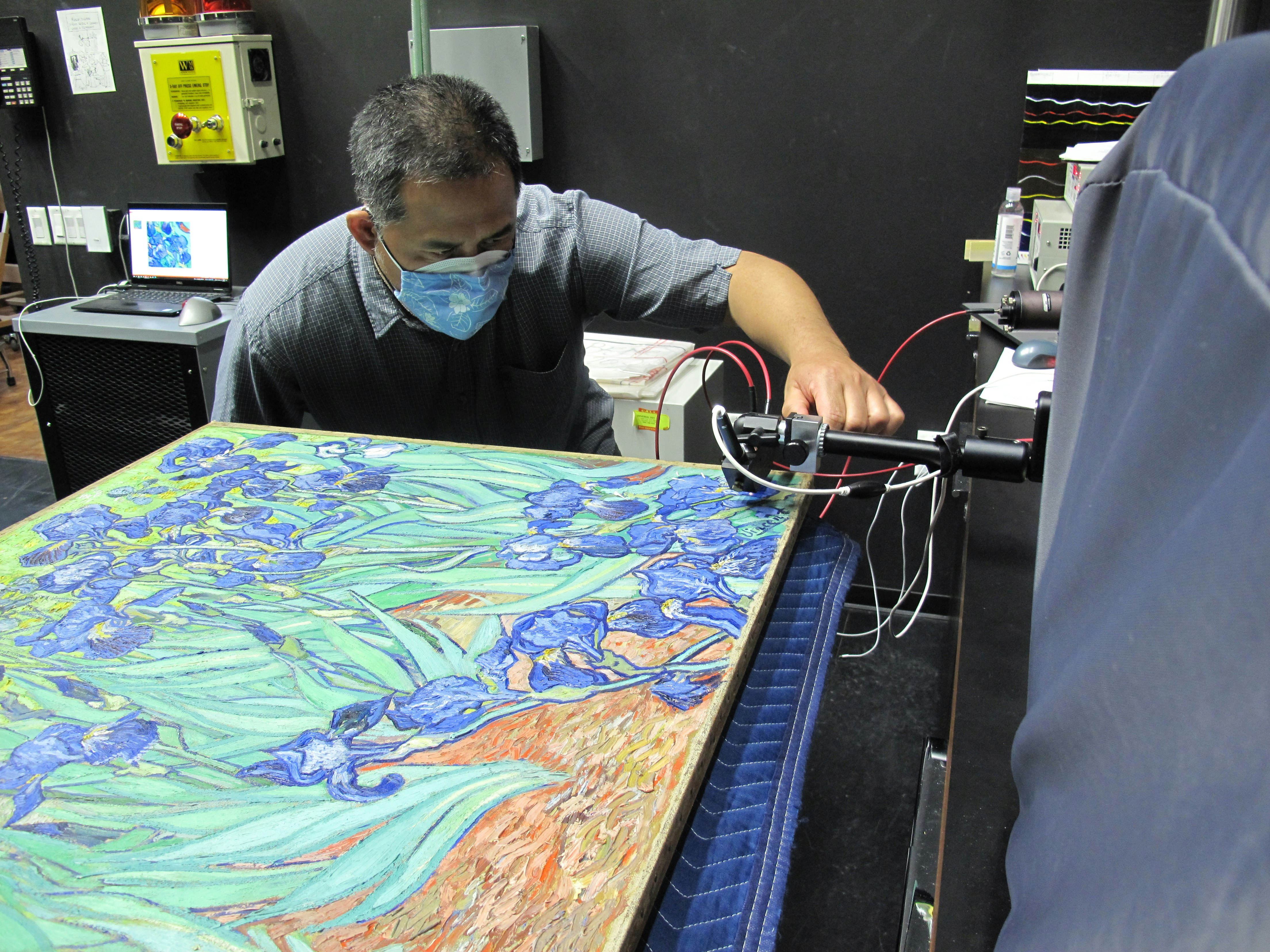 A GCI Scientist performs microfadeometry on van Gogh’s "Irises," a technique that helps us understand whether the paints are susceptible to discoloring upon exposure to light (Depicted: Vincent Beltran), 2021. Photo credit: Catherine Patterson. ©J. Paul Getty Trust.