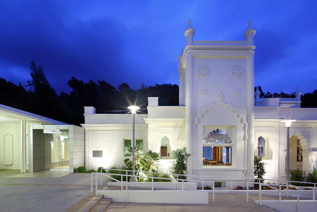 A photograph of a white building against a night sky.