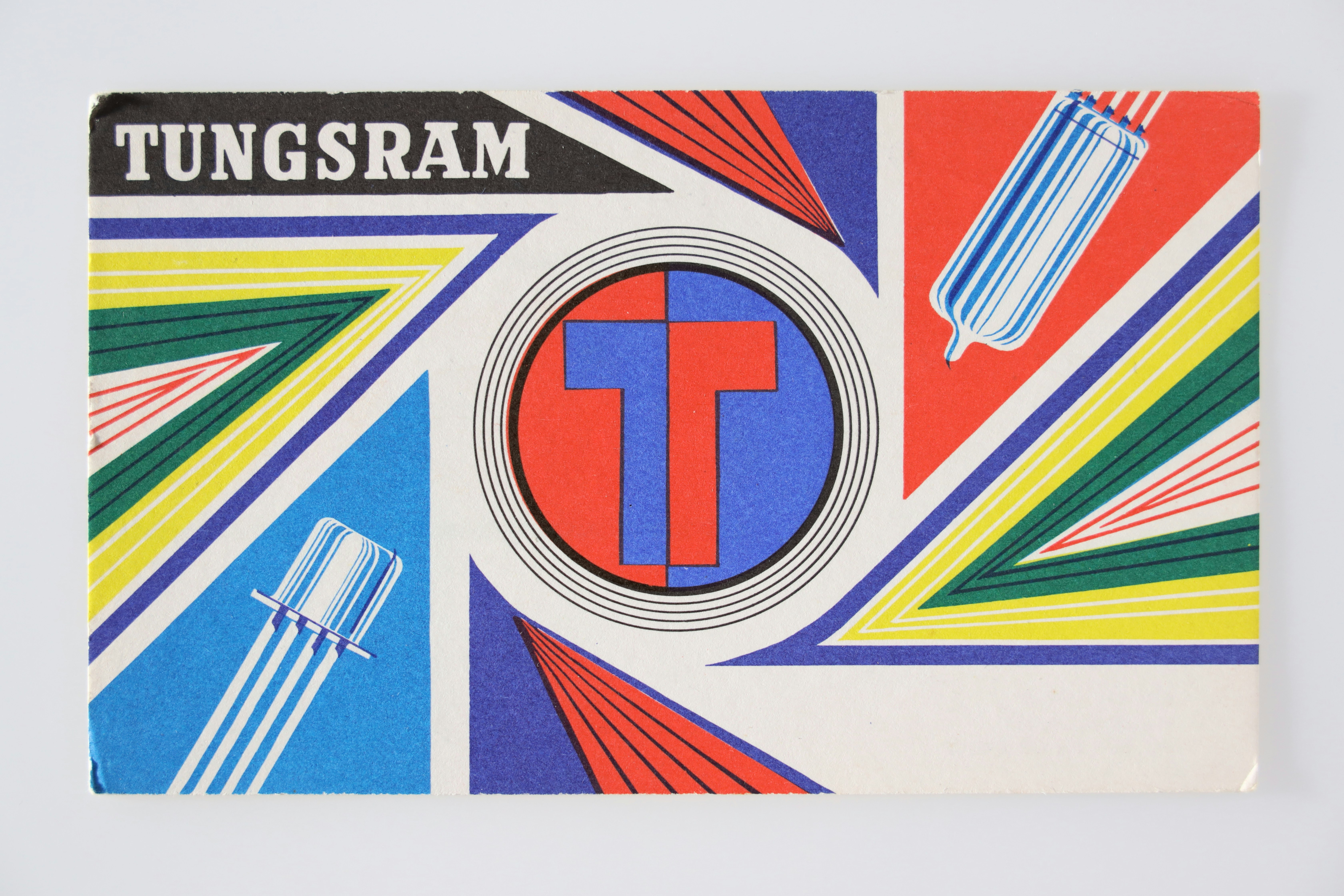 A rectangular card with graphic design elements in bright primary colors. In the center is the letter T in a circle, half blue and half red.